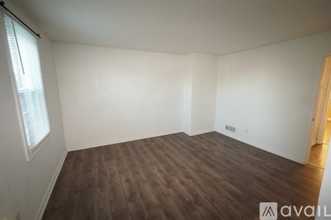 A room with a white door and a wooden floor.