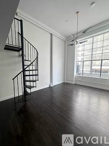 A room with a spiral staircase and a window.