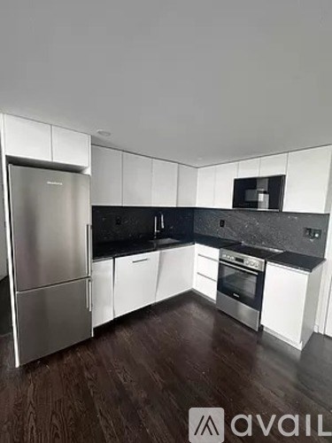 A kitchen with a refrigerator, oven, and microwave.