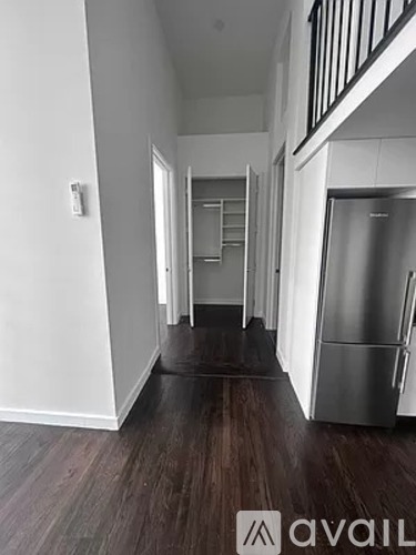 A hallway with a refrigerator on the right side.