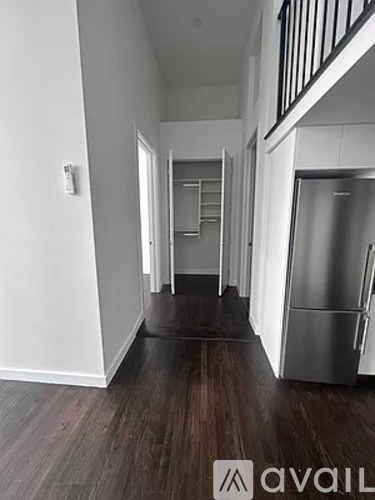 A hallway with a refrigerator on the right side.