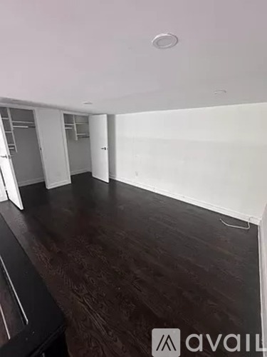 A room with wooden flooring and white walls.
