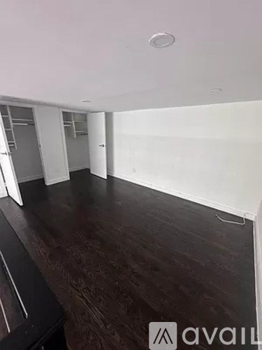 A room with wooden flooring and white walls.