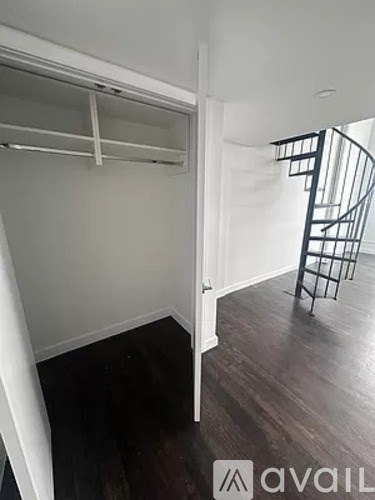 A room with a spiral staircase and a white door.