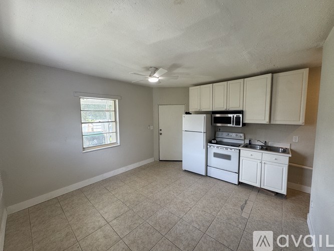 A kitchen with white appliances and cabinets is available for rent.