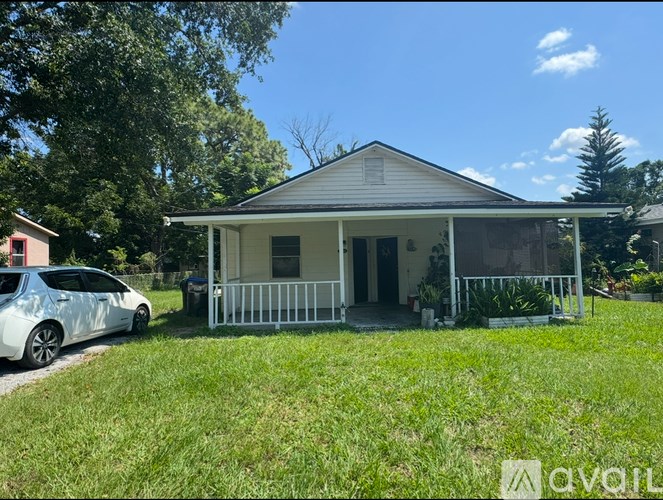 A small house with a car parked in front.
