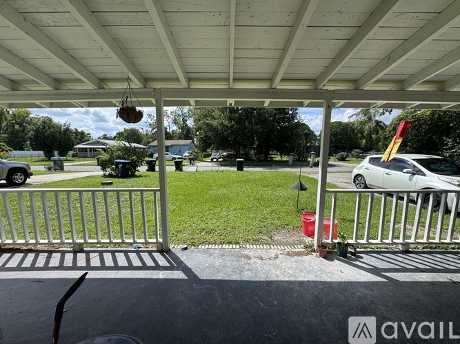 A white car is parked in a driveway.