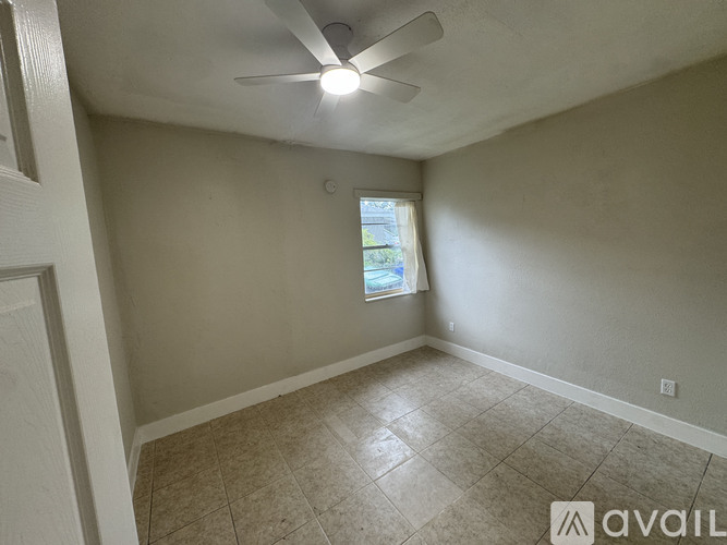 A room with a ceiling fan and a window.