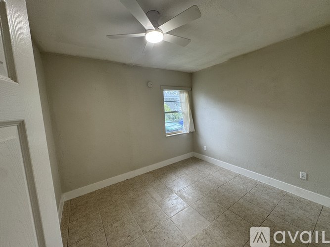 A room with a ceiling fan and a window.