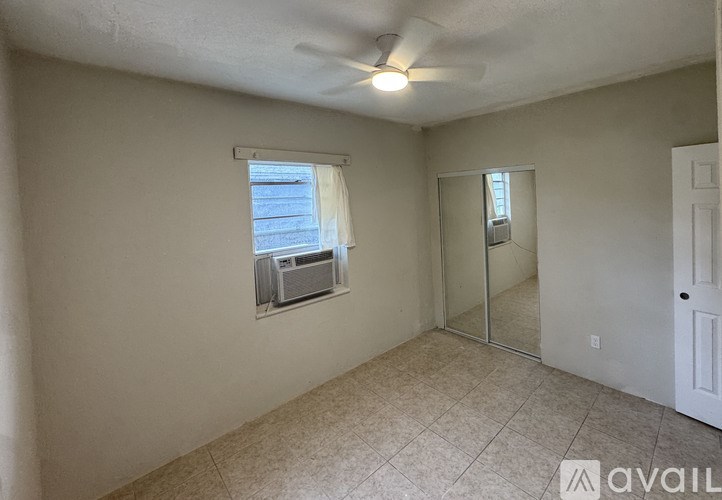 A room with a ceiling fan and a sliding glass door.