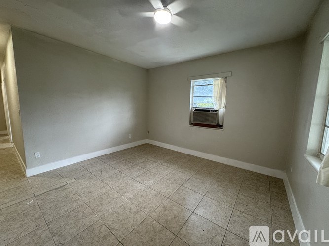 A room with a window and tiled floor.