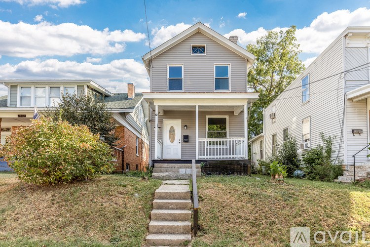 A house with a front porch and a white door is for sale.