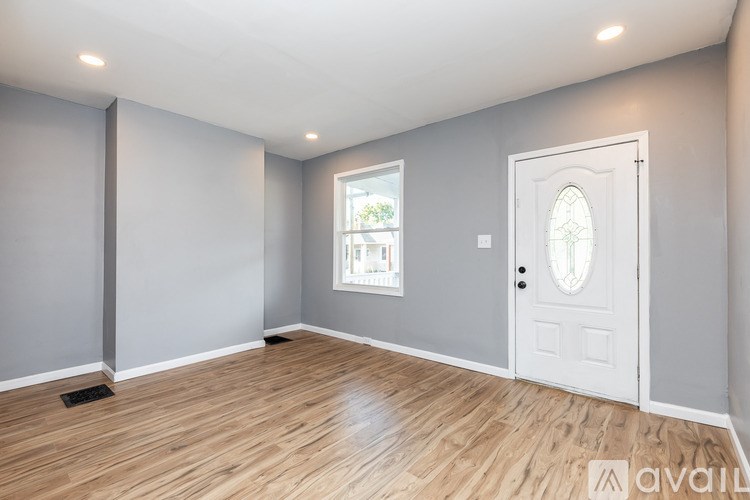 A room with a wooden floor and a white door.
