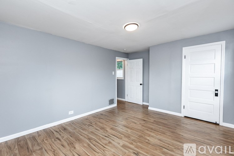 A room with wooden floors and two white doors.