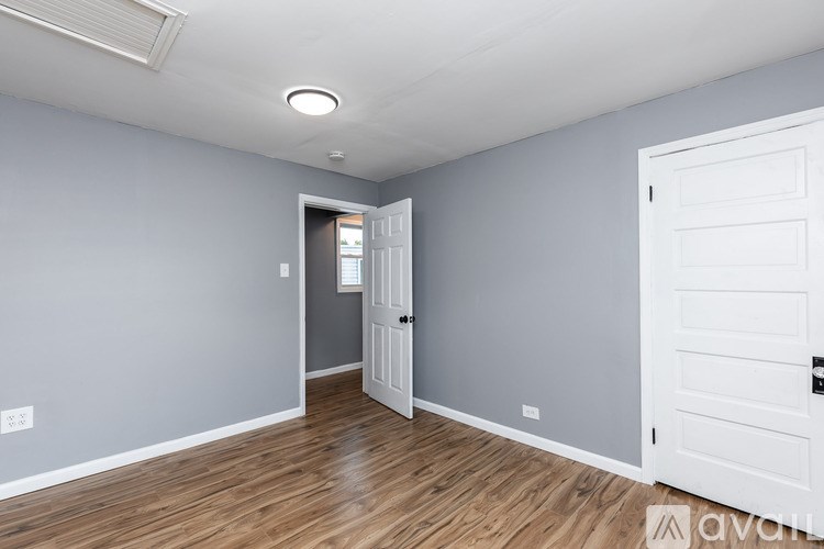 A room with a white door and a light on the ceiling.