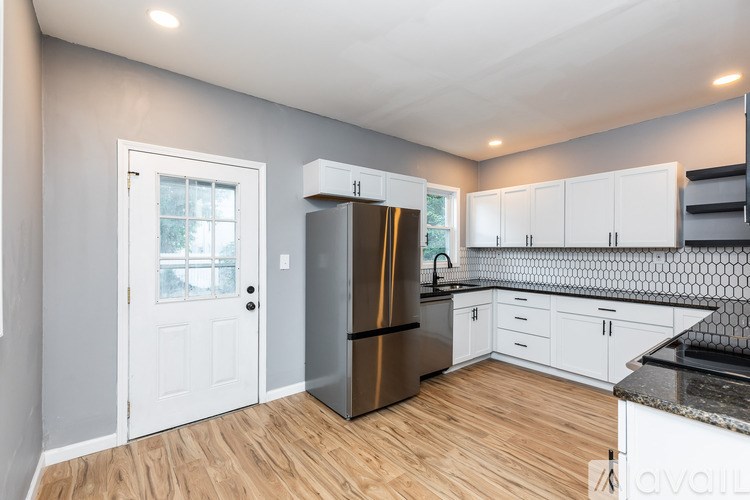 A kitchen with a refrigerator, cabinets, and a countertop.