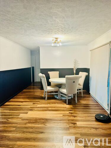 A room with a dining table and chairs.