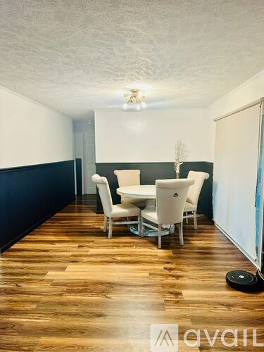 A room with a dining table and chairs.