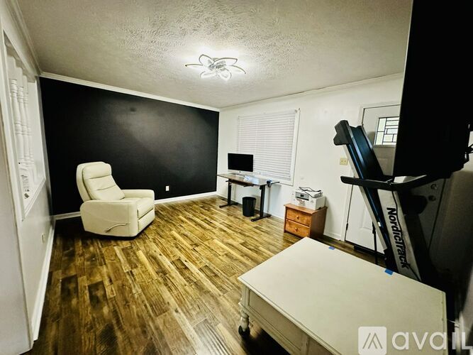 A room with a white chair and a wooden floor.