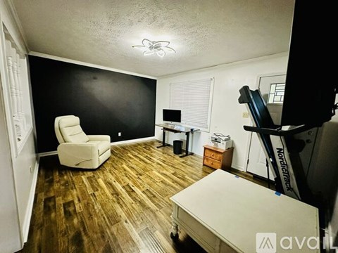 A room with a white chair and a wooden floor.