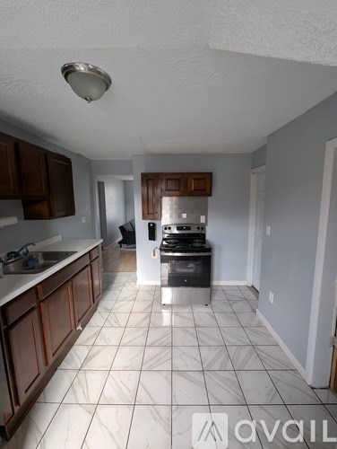 A kitchen with white tiled floors and brown cabinets.