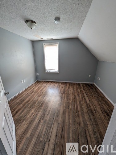 A room with wooden flooring and a window.