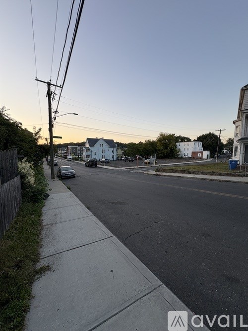A street view with houses on the side and a car parked on the side of the road.