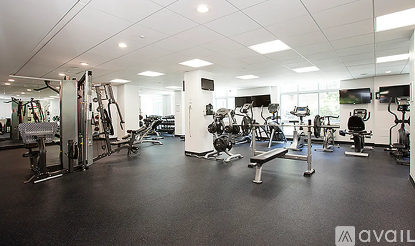 A gym with a variety of equipment including treadmills, weights, and exercise machines.