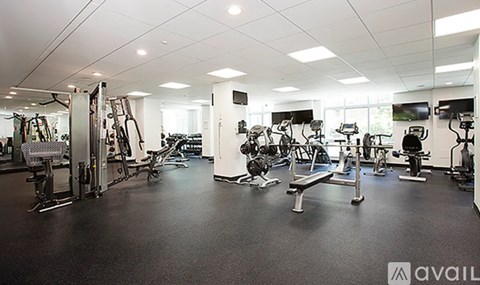 A gym with a variety of equipment including treadmills, weights, and exercise machines.