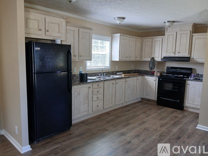 A kitchen with black appliances and wooden cabinets.