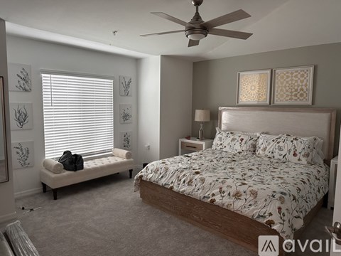 A bedroom with a large bed and a bench by the window.