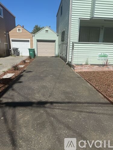 A driveway leads to a garage with a green door.