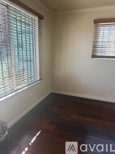A room with a window and wooden flooring.