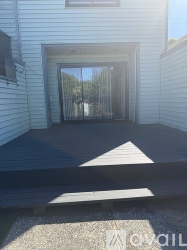 A white house with a black ramp leading to a glass door.