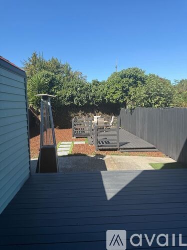 A backyard with a deck and a fence.