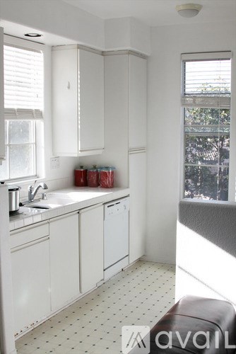 A kitchen with white cabinets and a sink.