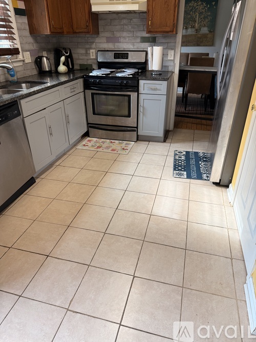A kitchen with a tile floor and a refrigerator.