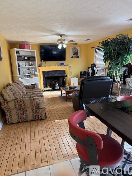 A living room with a fireplace, a chair, and a television.