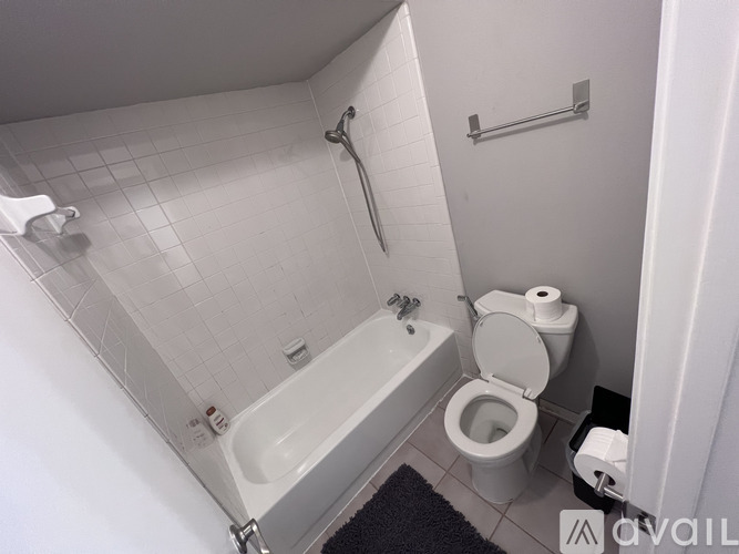 A white bathroom with a toilet, sink, and bathtub.