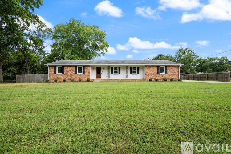 A house with a fence and trees in the background.
