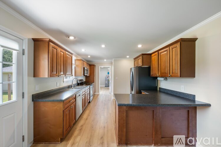 A kitchen with wooden cabinets and a black countertop.