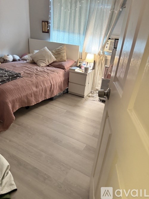 A bedroom with a bed, nightstand, and lamp.