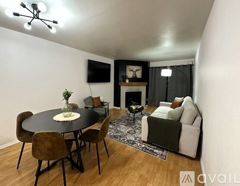 A living room with a black table and chairs, a fireplace, and a television.
