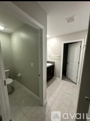 A bathroom with a toilet, sink, and mirror.