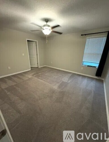 A room with a ceiling fan and a door.