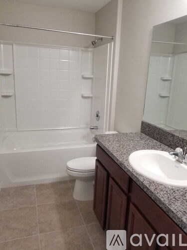 A bathroom with a white toilet and a white bathtub.