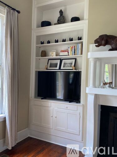 A living room with a fireplace and a television on a cabinet.