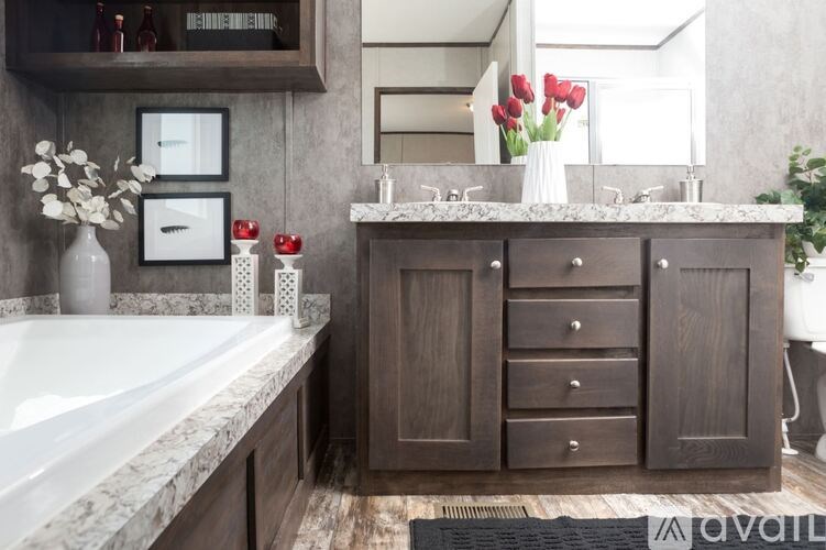 A bathroom with a marble countertop and a white bathtub.