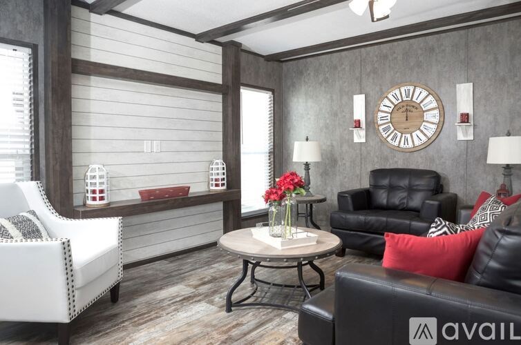 A living room with a black leather couch, a white sofa, and a wooden wall with a clock.