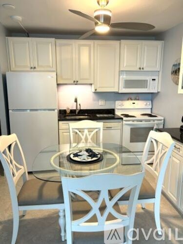 A kitchen with a table and chairs.